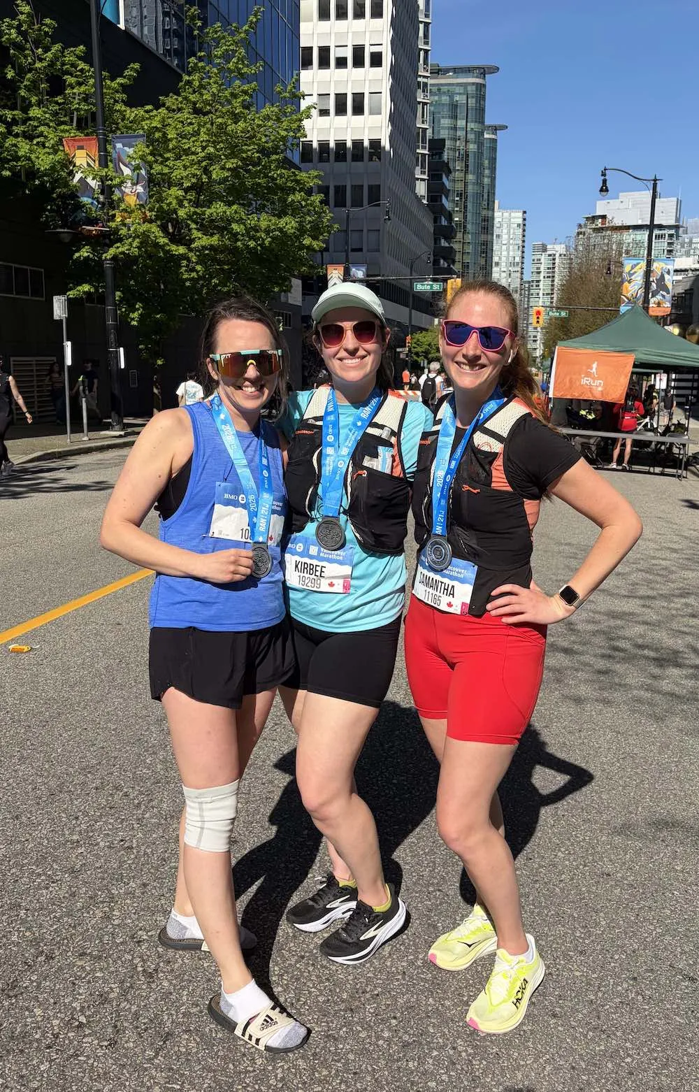 Three women wearing medals posing together after the race